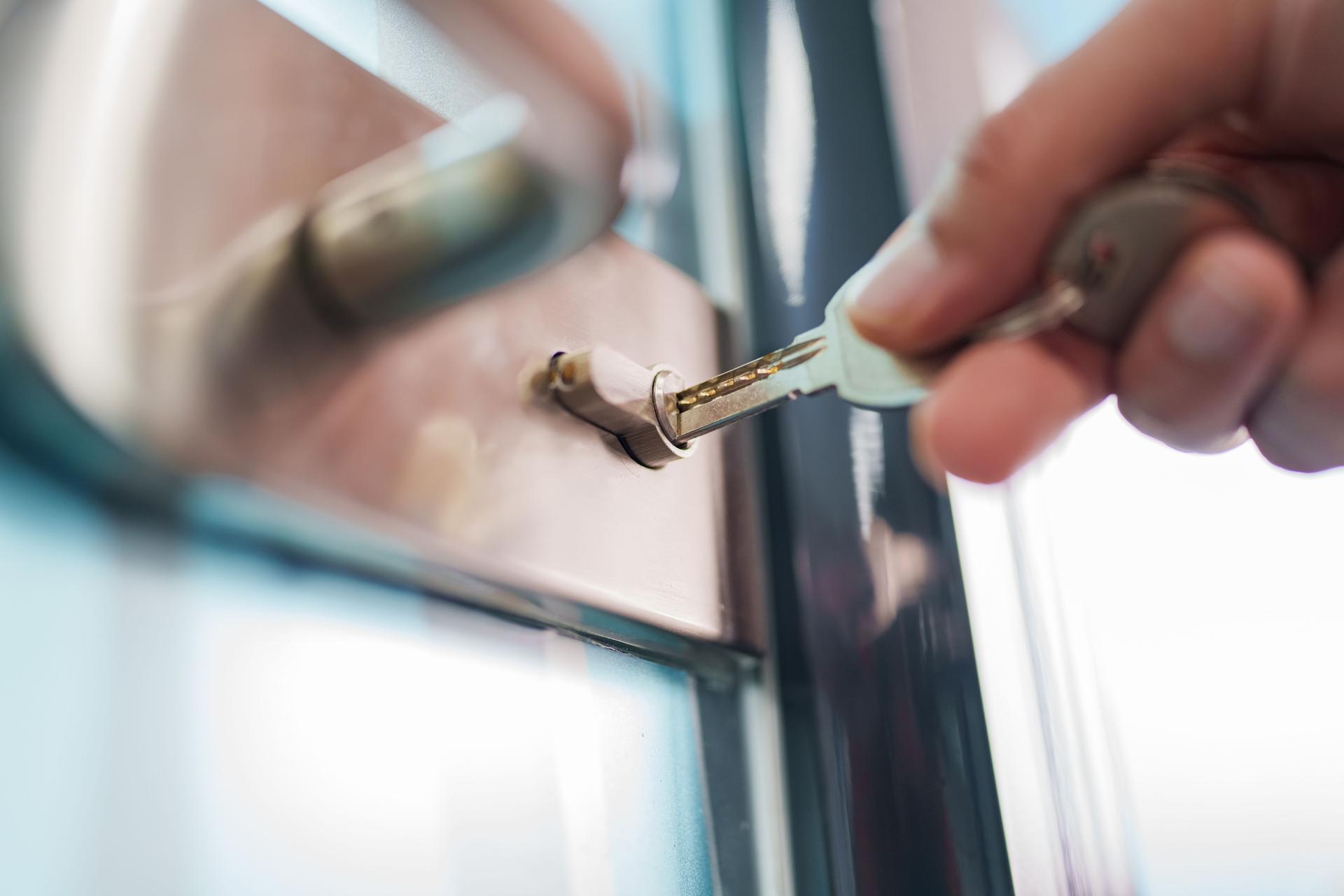 Close up to human hand holding keys on the lock